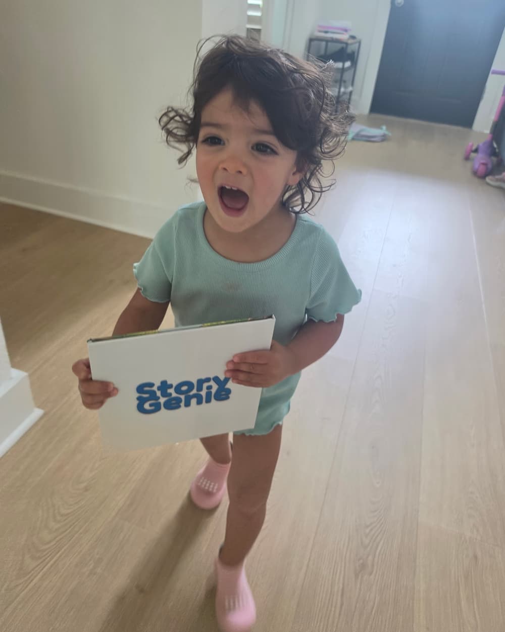 Lillian holding up her personalized Story Genie hardcover, mid-laugh